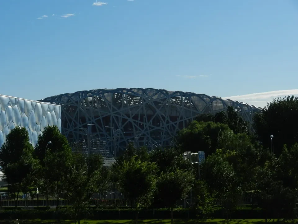 Una grande struttura architettonica moderna si trova all'interno di un parco verde.