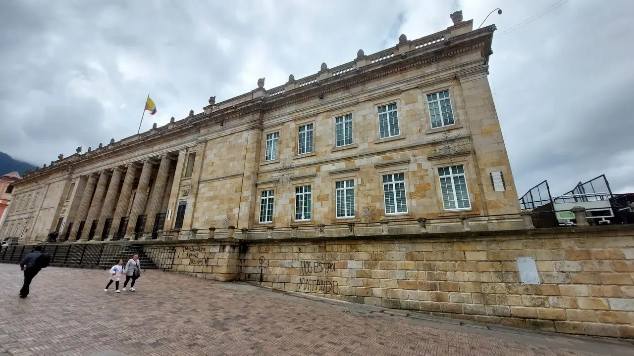 Facciata imponente di un edificio storico in pietra con colonne lungo la facciata.