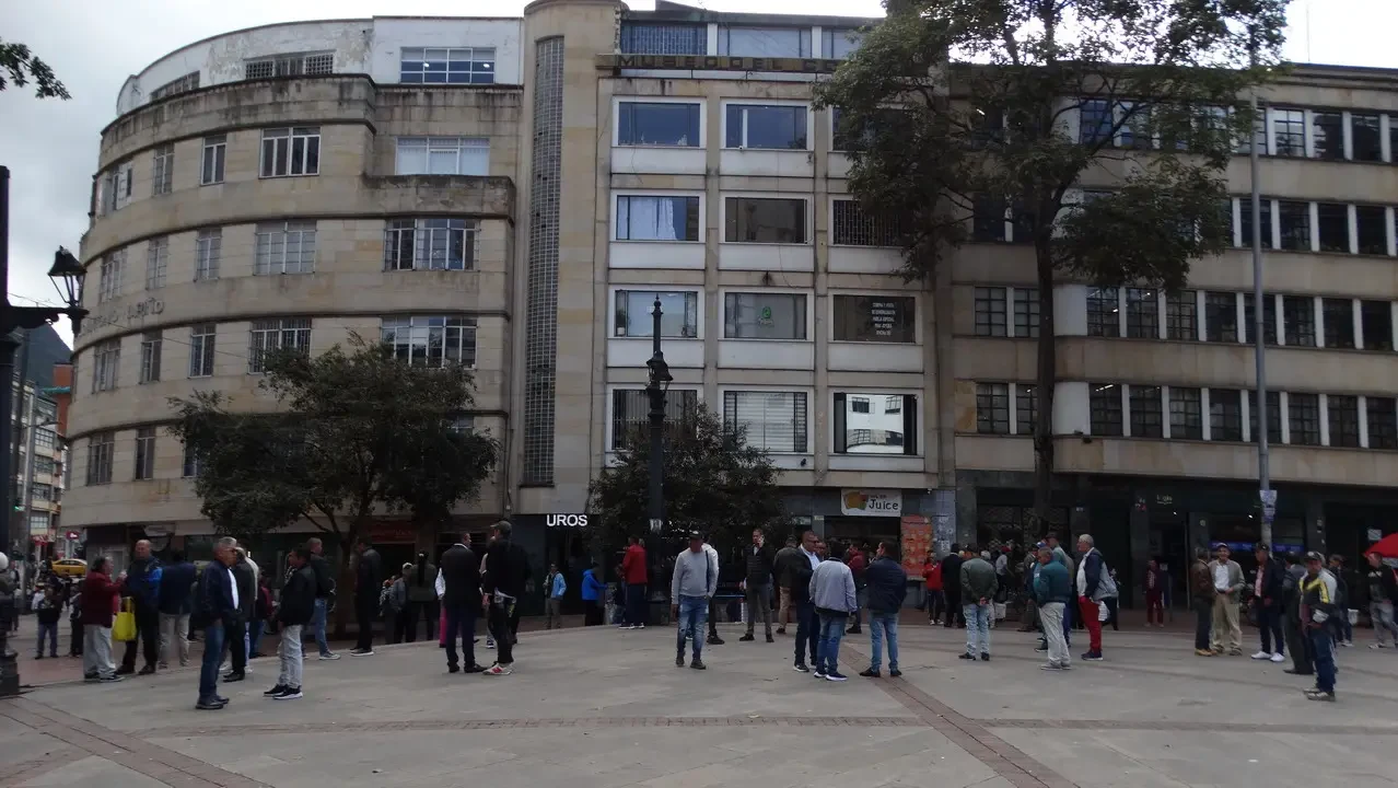 Una veduta di una piazza cittadina con edifici storici e persone in primo piano.