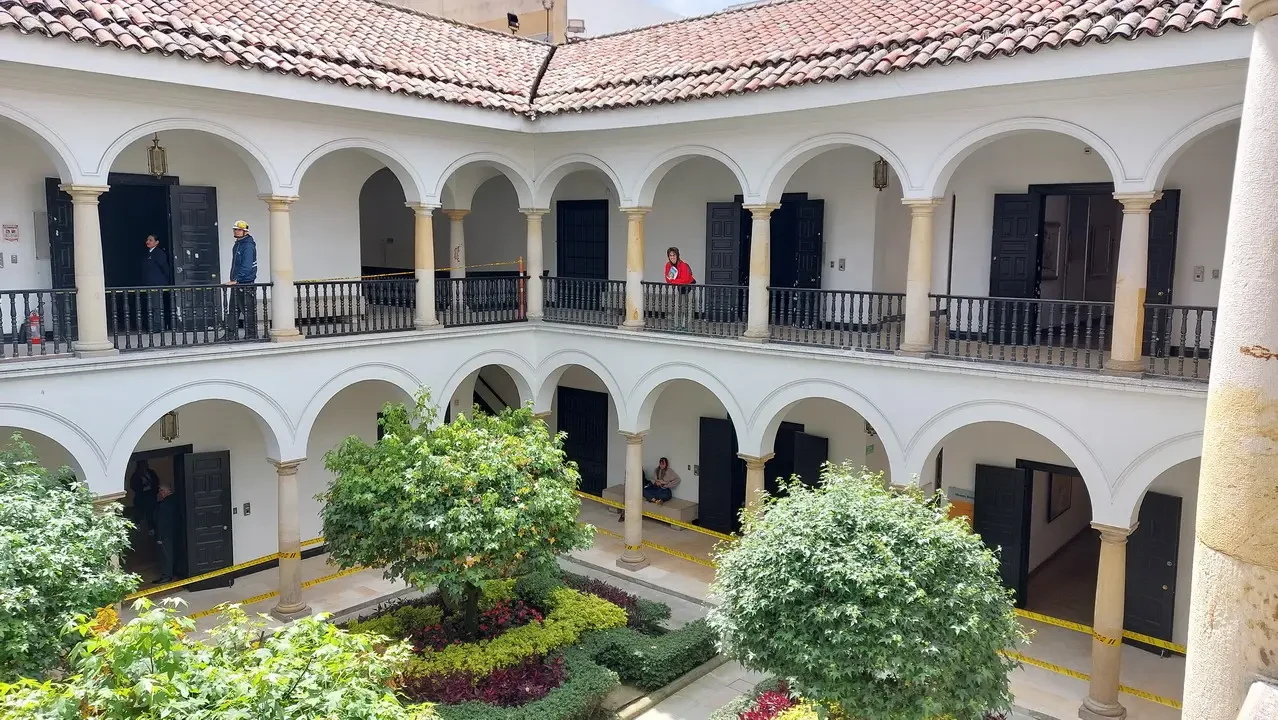 Vista di un cortile interno con archi e vegetazione in un edificio colombiano.