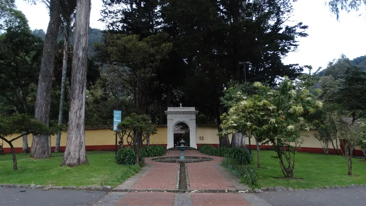 Una piazza con fontana e alberi in un parco colombiano.
