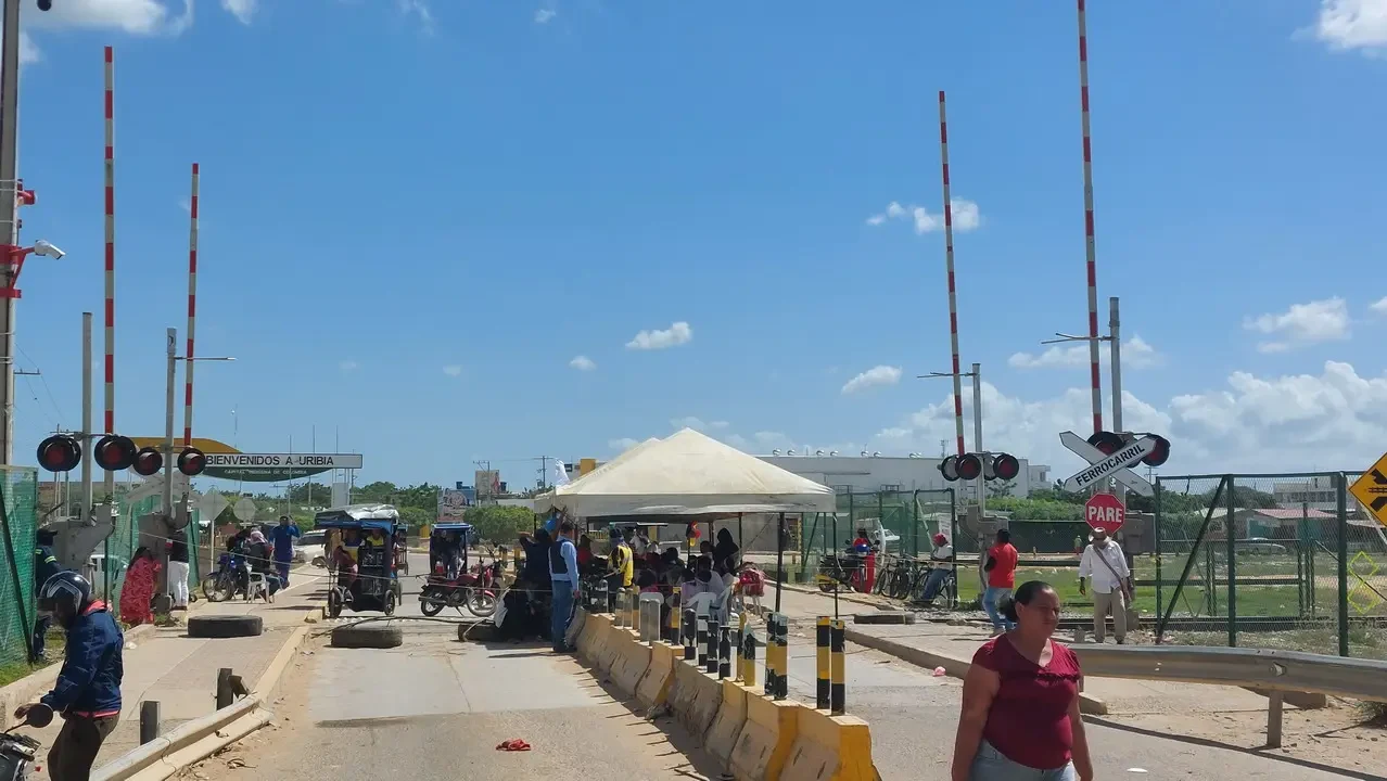 Una strada trafficata con veicoli e persone in un contesto colombiano.