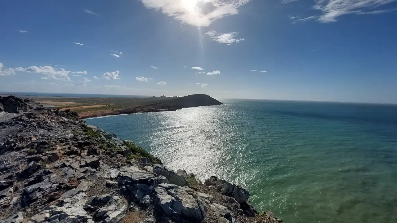 Paesaggio costiero con l'orizzonte aperto e il mare azzurro.