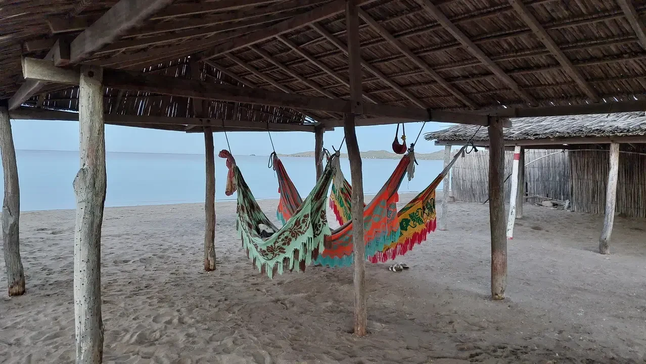 Un villaggio tradizionale in Alta Guajira, Colombia con strutture in legno e tessuti colorati sopraelevate.