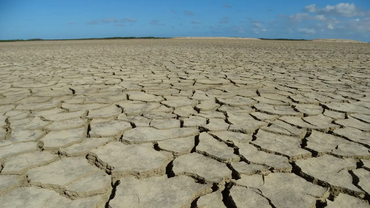 Paesaggio arido e incrinato della Guajira in Colombia sotto un cielo azzurro.