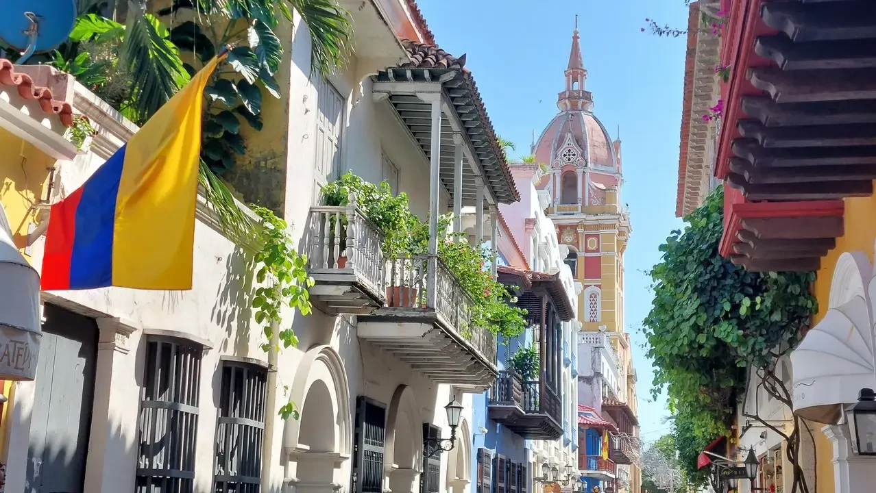 Una strada colorata e pittoresca a Cartagena con edifici storici e piante rampicanti.