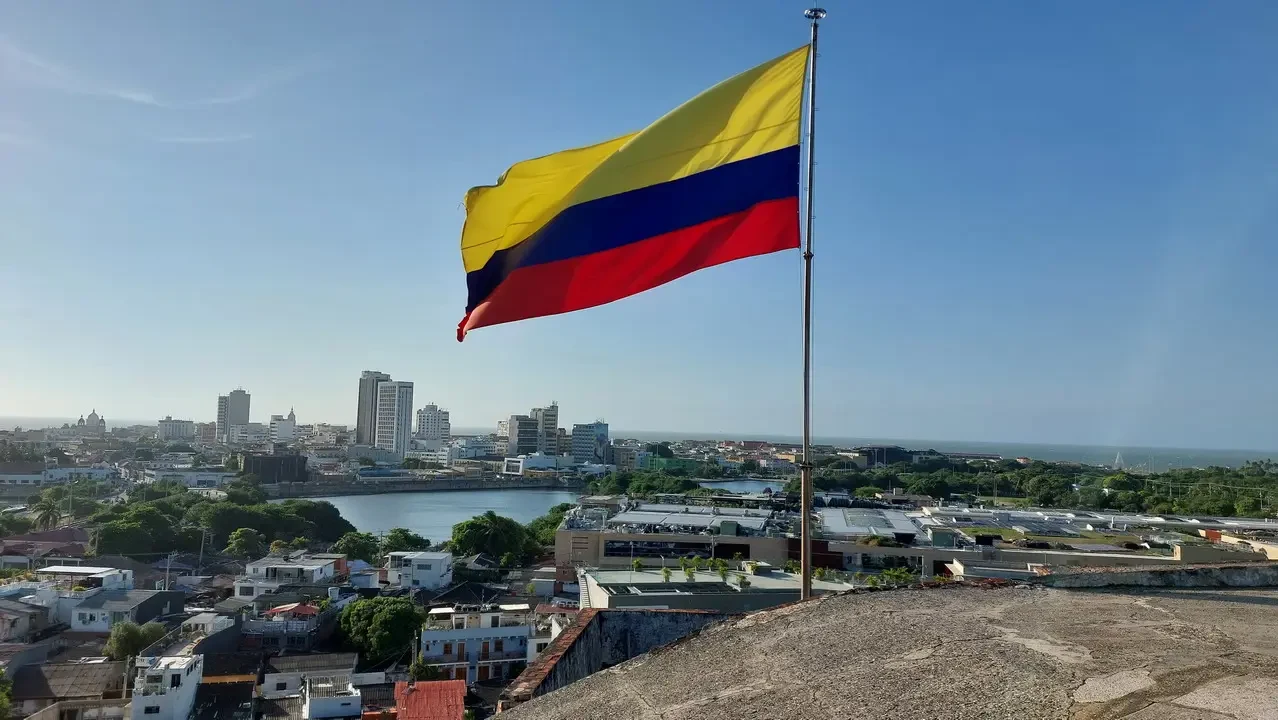 La bandiera colombiana ondea sopra una città costiera.