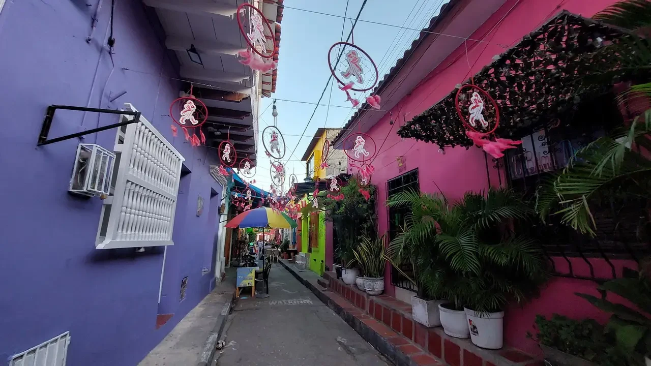 Una stretta strada colorata con balconi decorati in un quartiere colombiano.