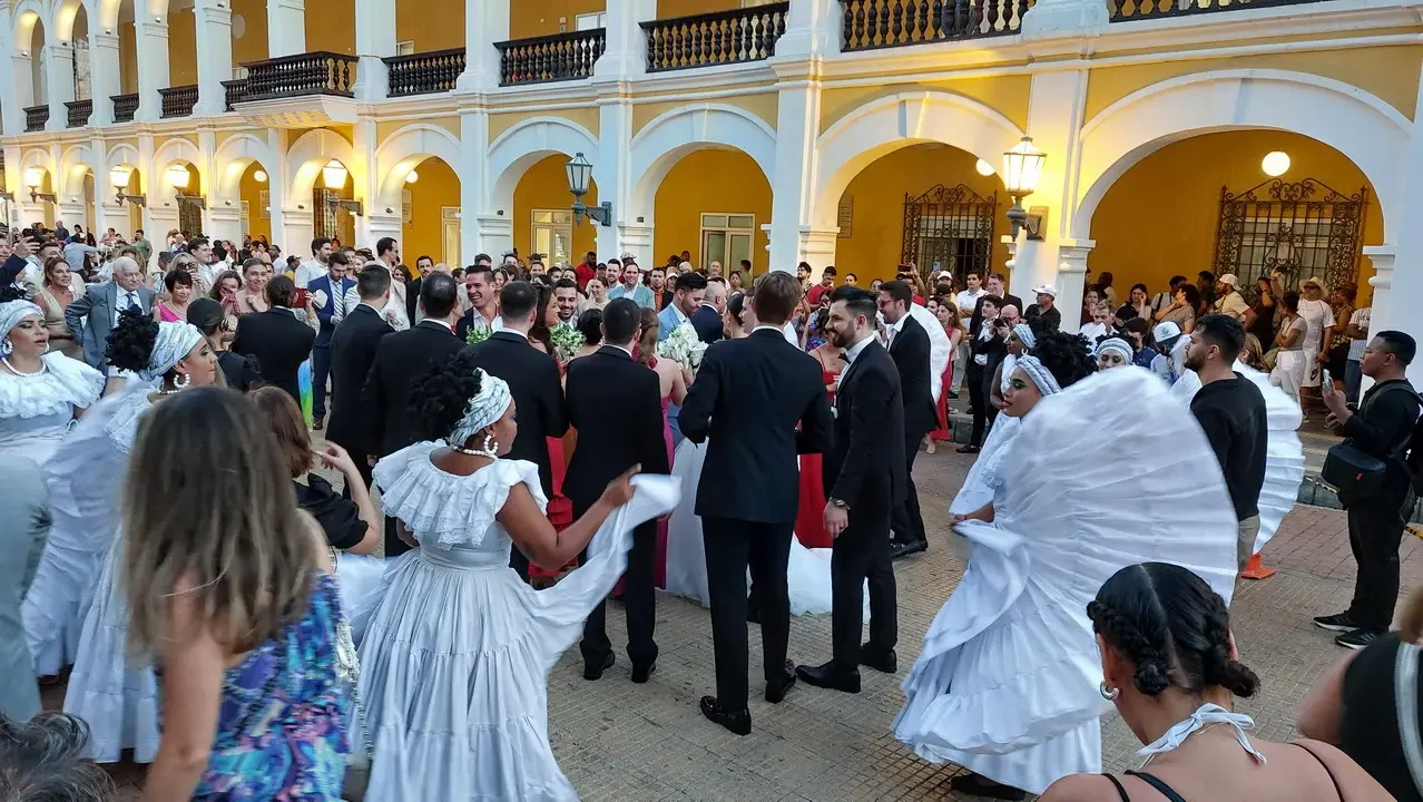 Un gruppo di persone è riunito in un elegante cortile colonnato durante un evento.