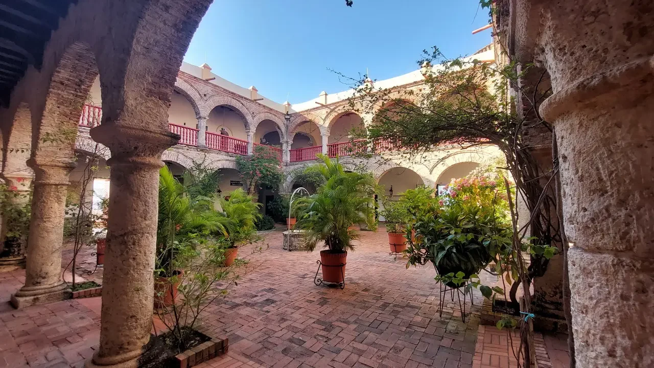 Cortile interno con archi e vegetazione in un cortile colonnato a Cartagena, Colombia.