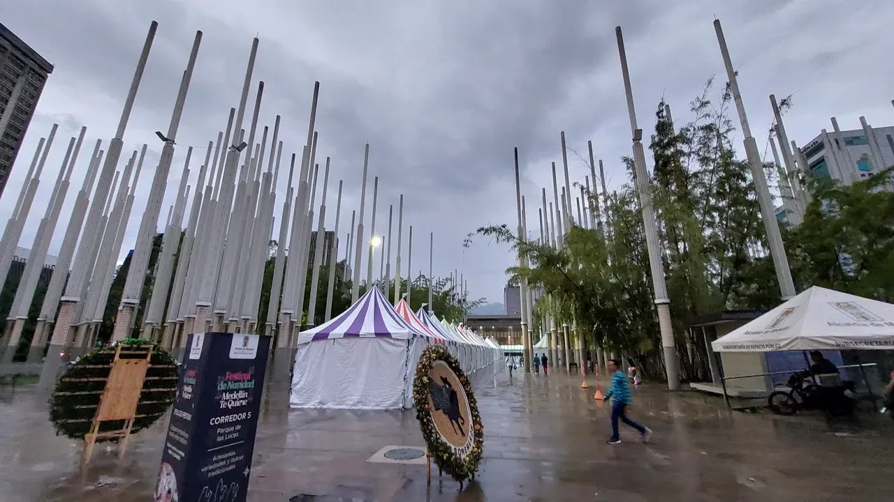 Una galleria di luci decorativa all'aperto in un parco colombiano sotto un cielo nuvoloso.