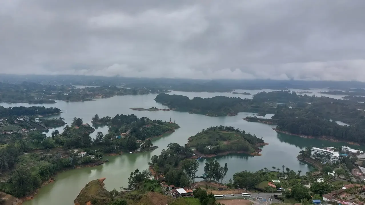 Paesaggio panoramico di un lago circondato da colline e vegetazione in Colombia.