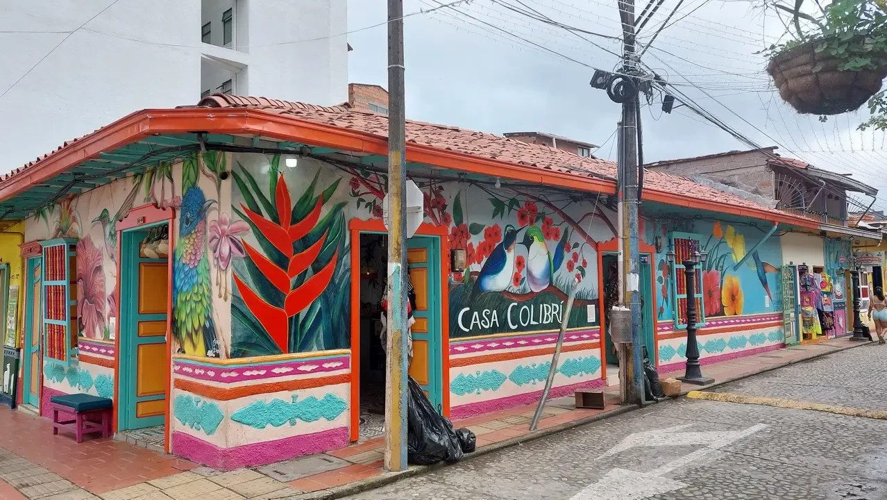 Facciata colorata di un edificio in stile colombiano con decorazioni murali vivaci.