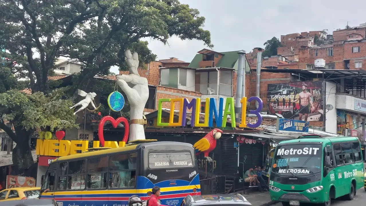 Una veduta di strada a Medellín con elementi artistici e veicoli pubblici.