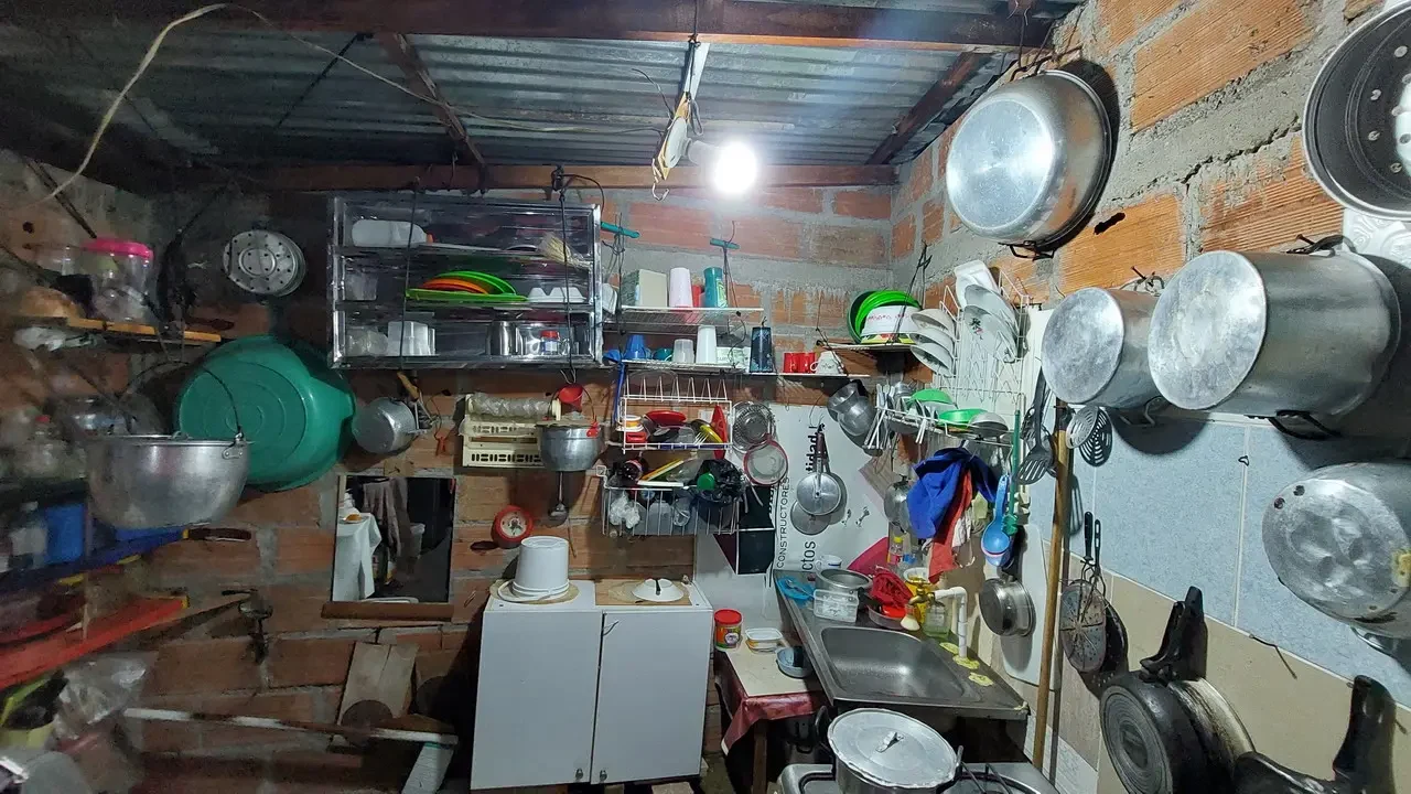 Interno rustico e affollato di una cucina o spazio abitativo in Colombia.