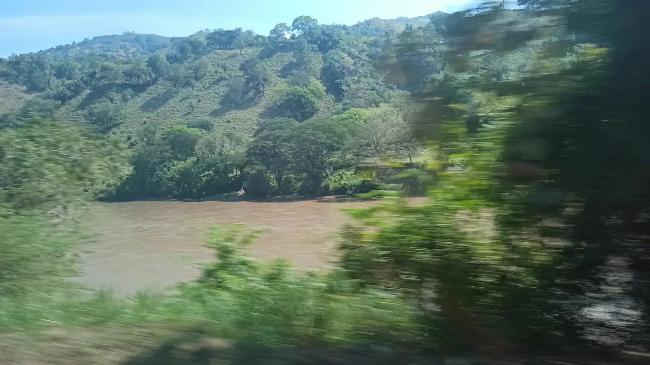 Un fiume marrone scorre attraverso una valle boscosa in Colombia.