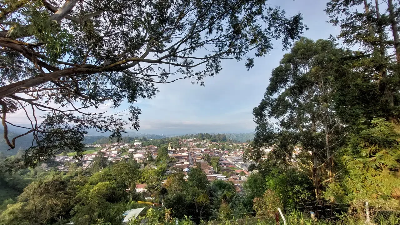 Vista panoramica di un paesaggio collinare con un insediamento sottostante in Colombia.