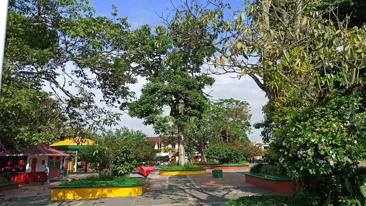Un parco verde con alberi e aree gioco in Colombia.