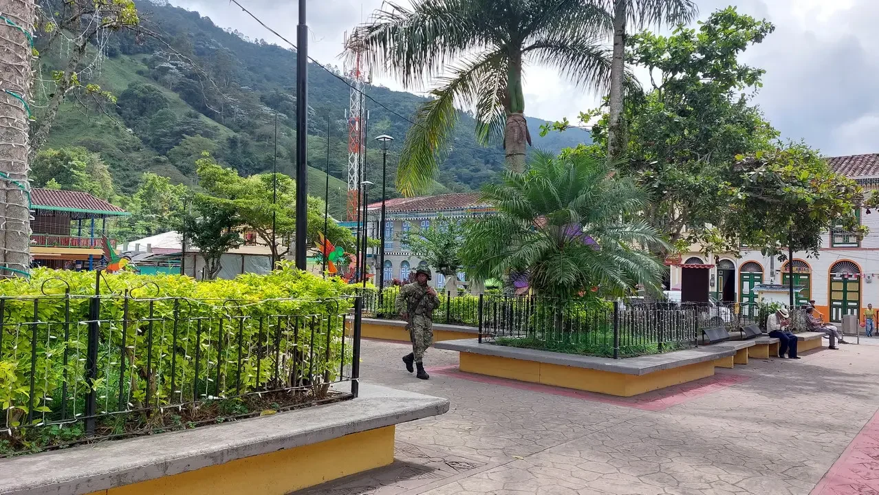 Vista panoramica del paesaggio collinare colombiano con edifici in primo piano.