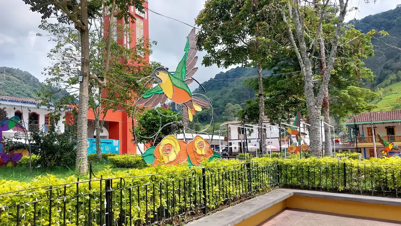 Paesaggio collinare con sculture colorate e vegetazione lussureggiante in Colombia.