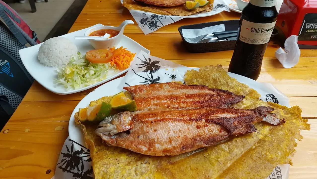 Un pasto di pesce e accompagnamenti in un contesto di viaggio colombiano.