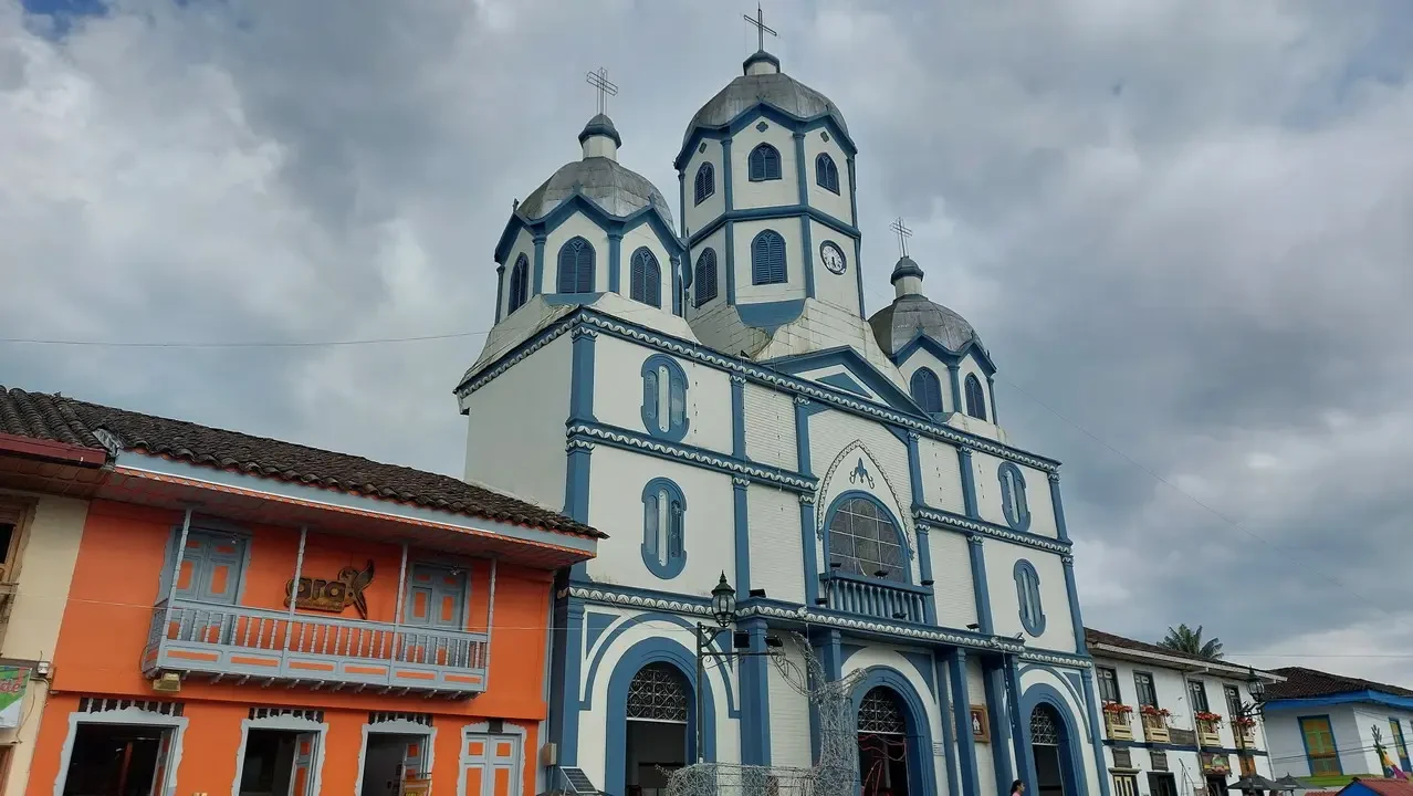 Vista esterna di una chiesa colorata in un paesaggio colombiano.