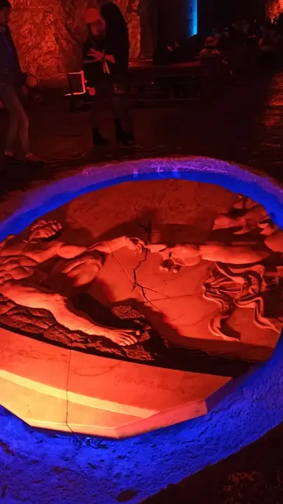 Scultura in pietra illuminata mostra una scena classica.