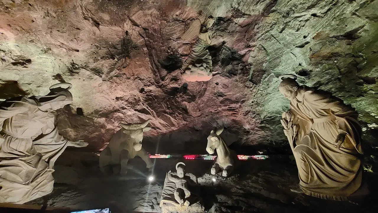 Interno di una grotta con sculture religiose in pietra.