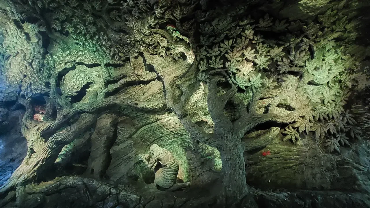 Un tronco d'albero massiccio e frondoso all'interno di una grotta naturale in Colombia.