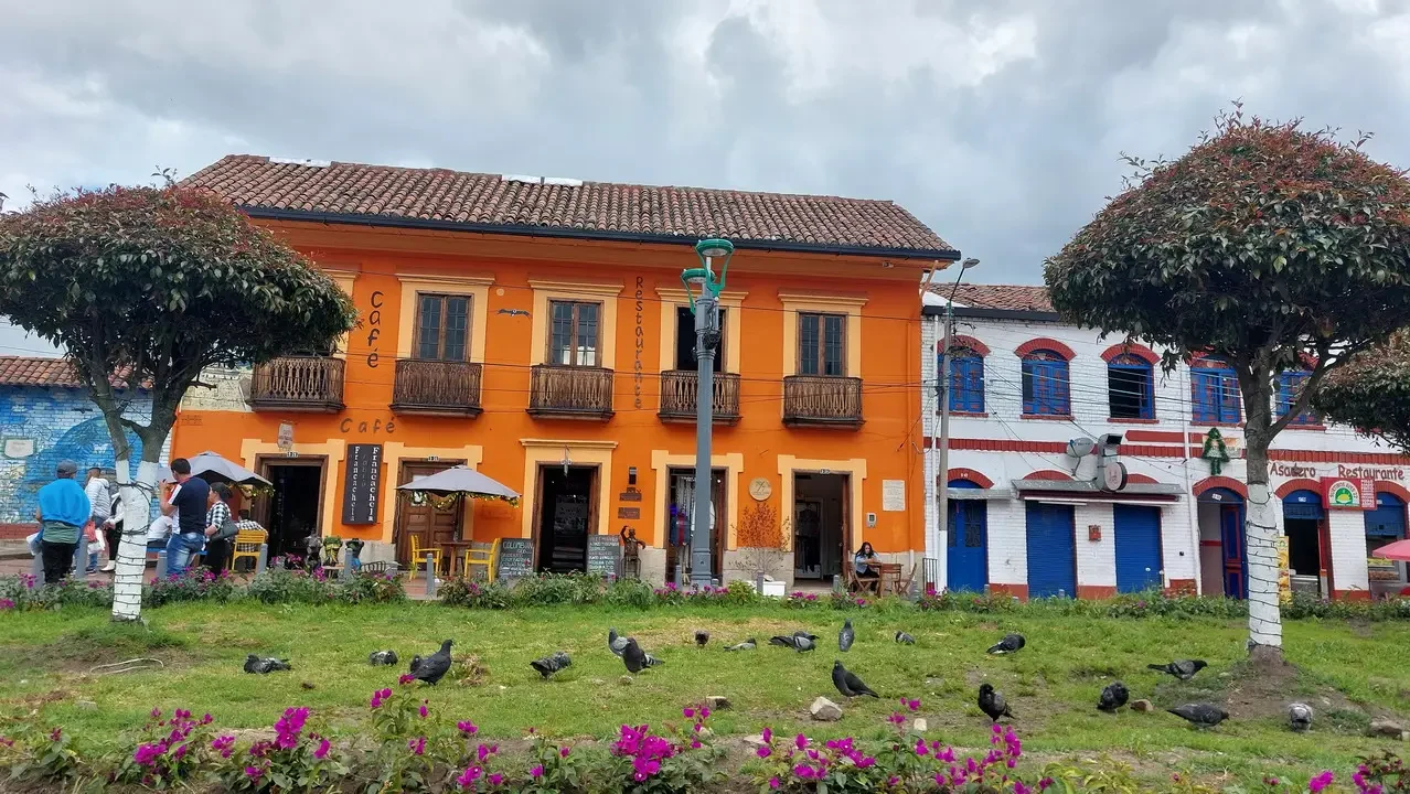 Una fila di edifici colorati con balconi in un contesto esterno colombiano.