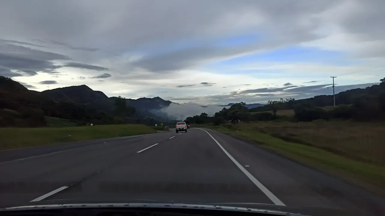 Una strada panoramica attraversa paesaggi collinari in Colombia al tramonto.