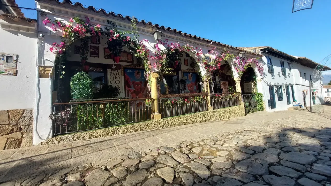Facciata di un edificio storico colombiano decorata con fiori e archi.