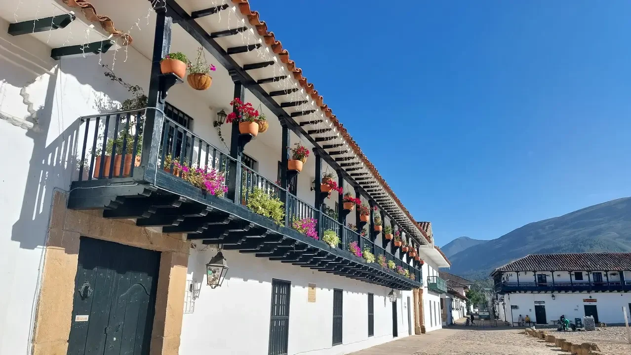 Facciata di una casa coloniale in Colombia con balconi fioriti.