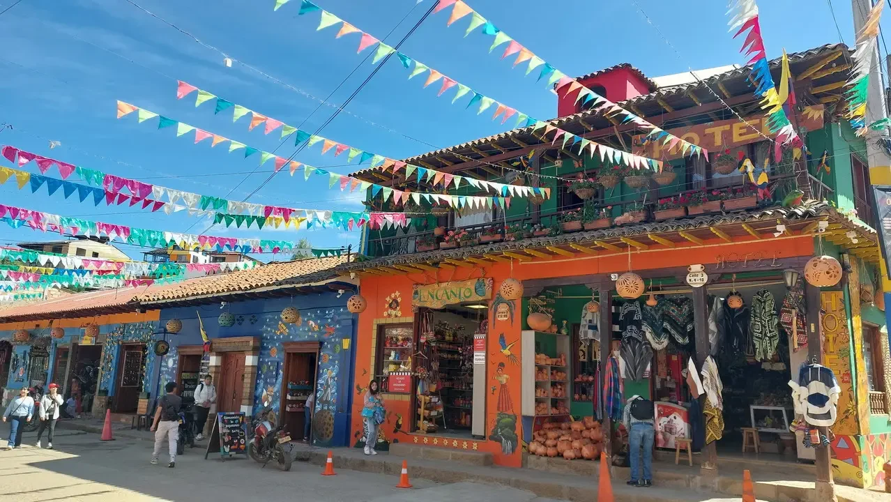 Una vivace strada di un paese colombiano con edifici colorati e decorazioni festose.