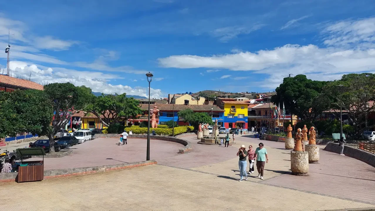 Una piazza storica colombiana con edifici colorati e una passeggiata aperta.