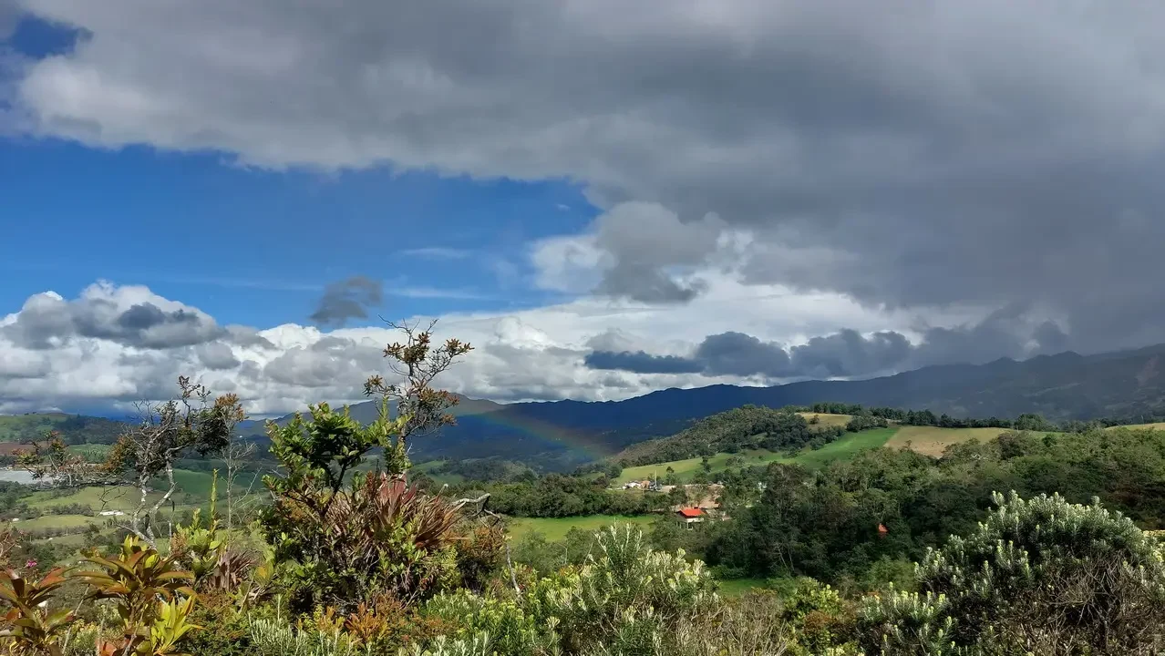 Un lago si riflette tra le montagne e le nuvole in Colombia.