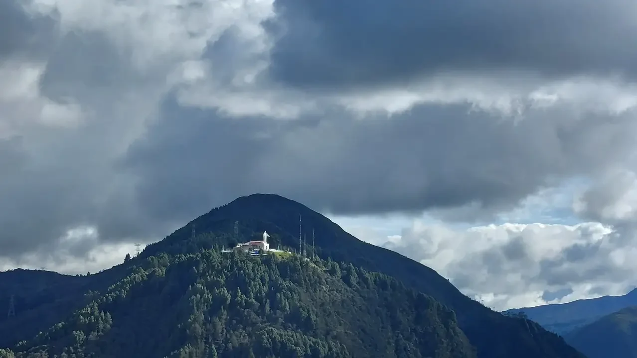 Vista panoramica di una montagna coperta da nuvole sopra un santuario in Colombia.