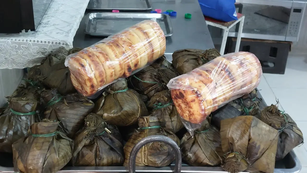 Vendita di prodotti alimentari avvolti in foglie di banano su un tavolo.