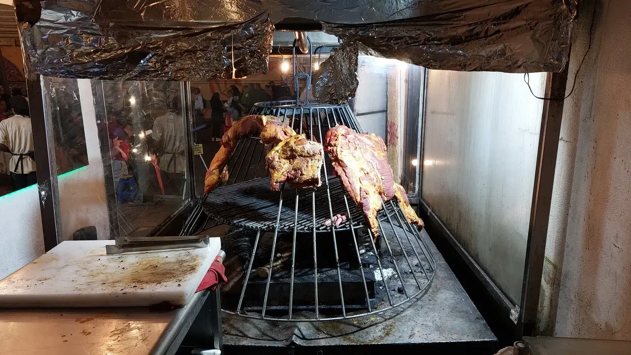 Carne alla brasa viene cucinata su una griglia in un contesto colombiano.