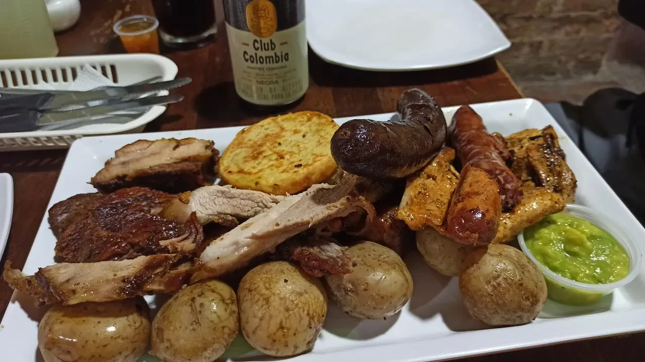 Un pasto di cena in stile colombiano con carne e accompagnamenti.