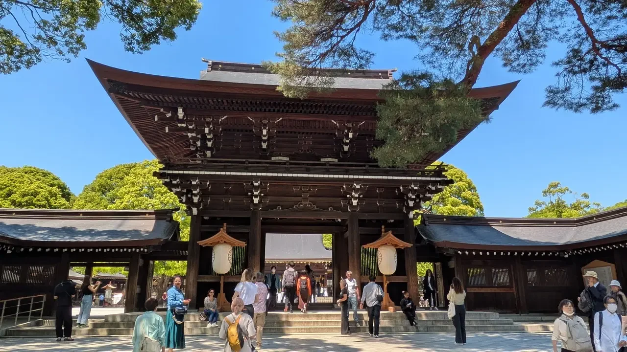 Porta del Santuario Meiji in Giappone con alberi verdi circostanti.