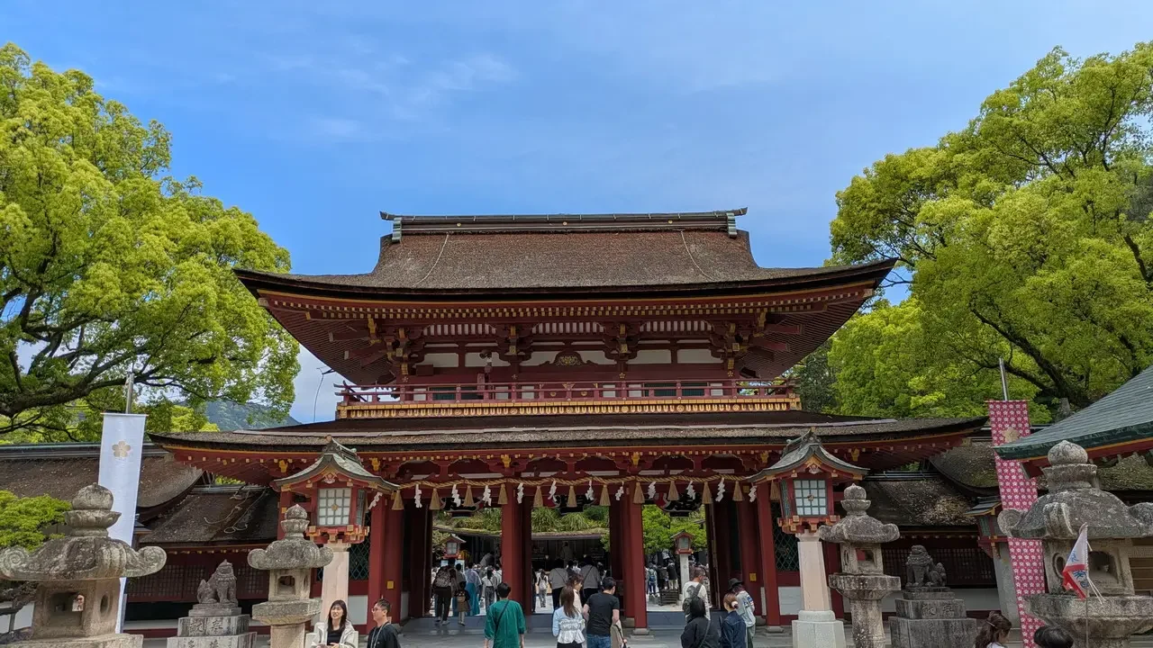 Vista frontale del santuario Dazaifu Tenmangu con un cortile alberato.
