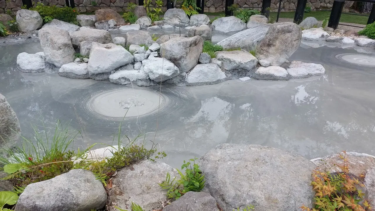 Una fontana rocciosa con acqua chiara e rocce chiare in primo piano.
