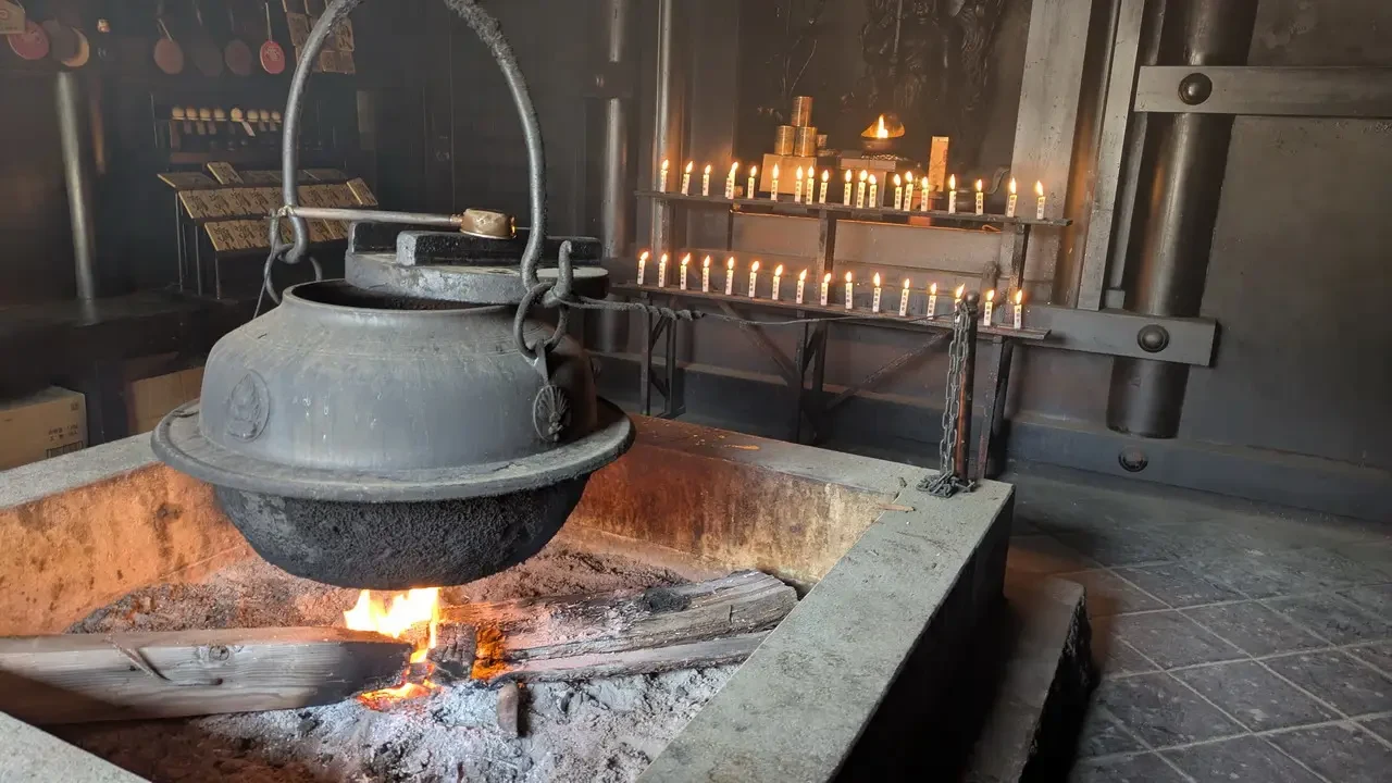 Un altare in legno con candele illumina un ambiente interno rustico.