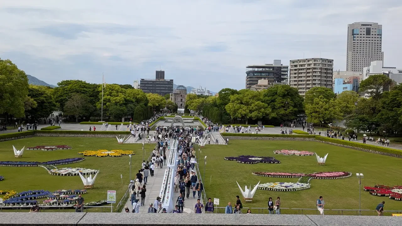 Vista panoramica del Parco della Pace a Hiroshima con una folla di visitatori.