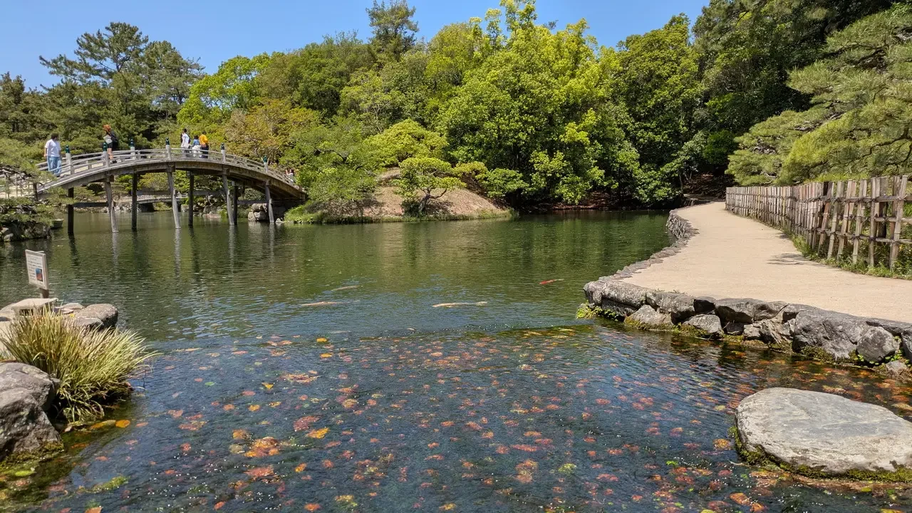Giardino Ritsurin in Giappone con un ponte sopra l'acqua.