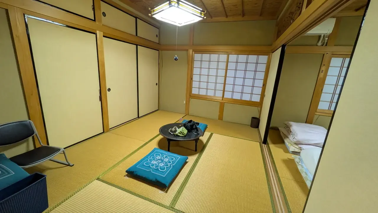 Interno di un ryokan giapponese con pavimento in tatami e porte shoji.