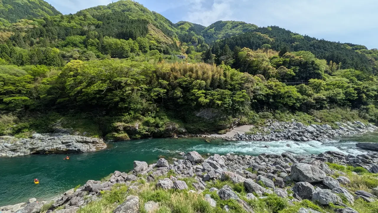 Paesaggio naturale verde con fiume e rocce in Giappone.