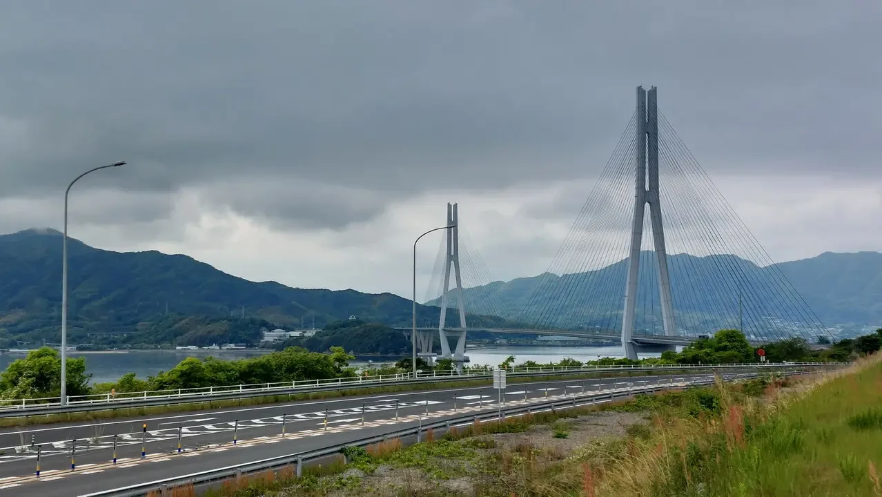Ponte sospeso attraversa un paesaggio montano e acquatico in Giappone.