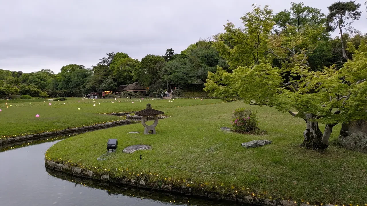 Giardino giapponese con un canale e alberi lussureggianti.